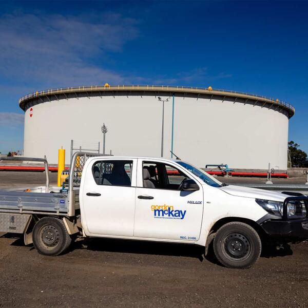 Gordon McKay ute in front of tank where industrial electricians performed electrical maintenance in Melbourne